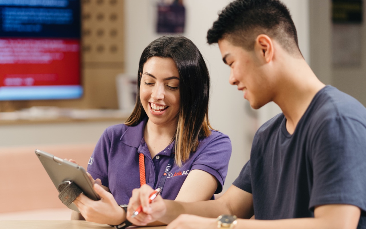 Two students looking at a tablet