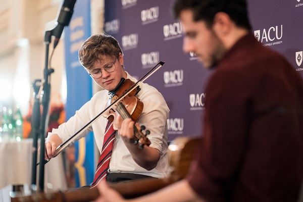 man playing violin on stage