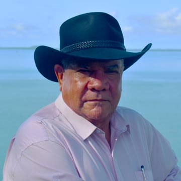 Mick Dodson outside wearing a hat.